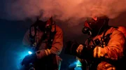 Duisburg in den frühen Morgenstunden: Noch vor Sonnenaufgang schlagen Flammen aus dem Fenster eines Mehrfamilienhauses. In der Brandwohnung erschwert dichter Rauch die Sicht, so dass die Feuerwehrleute die Brandursache zunächst nicht ausfindig machen können.
