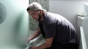 Dennis and Mustafa swap a shower partition in Hamburg's Langenhorn district.