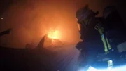 Ein Feuerwehrmann löscht das Feuer.