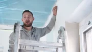 Sebastian and Heinrich install a ceiling made of mineral fibers in the office wing of a new building in Schloß Holte-Stukenbrock.