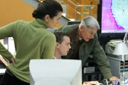 Auch die Weihnachtszeit bedeutet Arbeit für das NCIS-Team. Ziva (Cote de Pablo, l.), McGee (Sean Murray, M.) und Gibbs (Mark Harmon, r.) scheinen einer Verschwörung auf die Spur gekommen zu sein ...