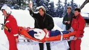 Dr. Stefan Frank (Sigmar Solbach, M.) und Ferdl Beer (Josef Baum, 2.v.r.) haben den todkranken Henning Beer (Horst Kotterba) in der Skihütte gefunden. Die Notärzte bringen ihn zum Hubschrauber.