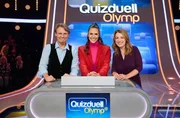 Quizmasterin Esther Sedlaczek (M.) mit den Kandidat:innen des Teams "GZSZ-Stars": Wolfgang Bahro (l.) und Iris Mareike Steen (r.), beide Schauspieler:innen.