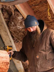 Matt arbeitet mit einem Bohrer im zweiten Stock der Hütte.