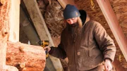 Matt arbeitet mit einer Bohrmaschine im zweiten Stock der Hütte.