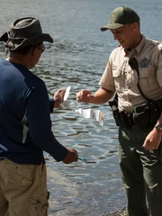 Officer Jon ensuring a fisherman is logging his catch.