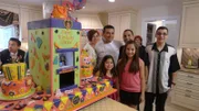 Buddy Valastro poses with family and elevator cake.A family poses with the elevator cake.