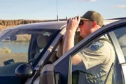Officer Bushing checking out the surroundings with binoculars.