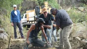 The team works together to pump water and dig.