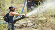 Kyle Seymour directing the hose that releases water that has been sucked up from the cistern.