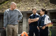 Arda (Yasemin Cetinkaya, r.) und Mark (Timmi Trinks, 2.v.r.) erfahren von Luca (Gareth Charles, l.), dass sein Chef kurzfristig nach Holland ist.