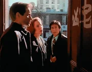 Obwohl Detective Glen Chao (B.D. Wong, r.) chinesischer Abstammung ist, kann er die Schriftzeichen an der Wohnungstür eines Mordopfers für Mulder (David Duchovny, l.) und Scully (Gillian Anderson, M.) nicht übersetzen.