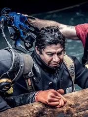 Carlos Minor and James Hamm at the edge of the dive site. James Hamm prepares Carlos Minor’s dive gear.