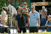 Finn (Florian Thürnagel, M.) besucht mit Papa Thomas (Sebastian Schlemmer, l.) und Opa Georg (Stefan Viering, r.) den Zoo (mit Komparsen).