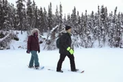 Chris und Jessi glätten mit ihren Schneeschuhen den Schnee auf dem zugefrorenen See.