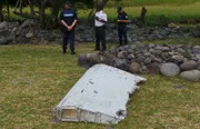 French gendarmes and police stand near a large piece of plane debris which was found on the beach in Saint-Andre, on the French Indian Ocean island of La Reunion. France's BEA air crash investigation agency said it was examining the debris, in coordination with Malaysian and Australian authorities, to determine whether it came from Malaysia Airlines Flight MH370, which vanished last year in one of the biggest mysteries in aviation history.