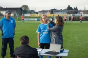Fleißig assistiert Lilli (Ronja Forcher, r.) ihrem Vater Martin (Hans Sigl, 2. v. l.) und überprüft unter Aufsicht von Trainer Jannek (Janek Rieke, l.) den Laktatwert der Fußballspielerin Sarah (Luna Jordan, 2. v. r.).