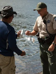 Officer Jon ensuring a fisherman is logging his catch.