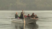 The Browns take a skiff to the island where they plan to camp.