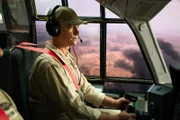 In dieser dramatischen Nachstellung sitzt Kommandopilot McBeth (gespielt von D.C. Williams) im Cockpit eines Lockheed Hercules C-130 Wasserbombers und bereitet sich auf den Abwurf von Löschmitteln in niedriger Höhe auf ein Feuer in Ostaustralien vor.