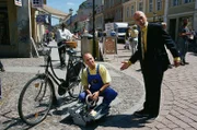 Peter (Peter Lustig, r.) entdeckt bei seinem Gang durch die Stadt sehr viele Leute, die Latzhosen tragen. Er würde so gerne seinen Anzug gegen eine Latzhose tauschen.