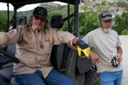 Duane Ollinger (l.) sitting in a four wheeler while Charlie Snider (r.) leans against it.