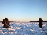 Jessi Morse and Chris Morse are on the final stretch across the Tanana River as one of the crew members gets it all on camera.