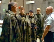SG-1 (v.li.n.re.: Richard Dean Anderson, Michael Shanks, Amanda Tapping, Christopher Judge) kommt von einem Einsatz zurück. General Hammond (Jon S. Davis) begrüßt die vier schon am Sternentor...