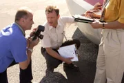 Der Schauspieler, der Bill Taylor darstellt, inspiziert die Nase des Flugzeugs und macht Fotos