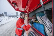 Overhalla, Norway - Roar Skjeflo picks up a strap to help the truck in the ditch.