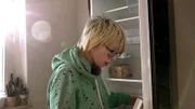 Die schwangere Jasmin räumt den Kühlschrank ein.