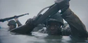 Der Gefreite Henry Parham (gespielt von Ishmel Bridgeman) watet am Omaha Beach in einer Szene einer historischen Nachstellung des Zweiten Weltkriegs für "Erased: WW2's Heroes of Color". Parham diente mit dem 320th Barrage Balloon Battalion am D-Day.