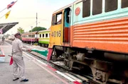 Mit grünen Fahnen geben die Fahrdienstleiter an den thailändischen Bahnhöfen die Einfahrt frei.