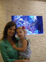 The Reuss family poses in front of one of their new fish tanks.