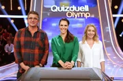Quizmasterin Esther Sedlaczek (M.) mit den Kandidat:innen des Teams "Bergdoktor": Dem Schauspieler Hans Sigl (r.) und der Schauspielerin Natalie O'Hara (l.).