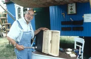 Peter (Peter Lustig) baut einen Fledermaus-Nistkasten vor seinem Bauwagen.
