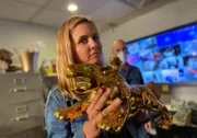 Mariana van Zeller in Allure's office holding a golden tiger statue.