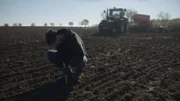 Landwirt Phillip Krainbring kontrolliert, ob das Saatgut tief genug in der Erde liegt.