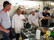 Im Bild von links: Küchenchef Jörg Schwab, Francis von Hoy, ein Auszubildender, Kapitän Morten Hansen. Der Küchenchef der "Grand Lady", Jörg Schwab, besucht in Ho-Chi-Minh-Stad/ Saigon gemeinsam mit Kapitän Morten Hansen die Gastronomieschule Mai Sen von Francis von Hoy. Der Vietnamese hat 36 Jahre in München gelebt und bildet nun in Vietnam Straßenkinder zu Köchen und Restaurantfachkräften aus – nach deutschem IHK-Standard.