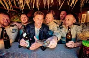 Zur Feier des Tages erstmal ein, zwei, drei… Bier! Franz Eberhofer (Sebastian Bezzel, 3.v.li.) und sein alter Polizeischulkollege Kuglmayer (Michael A. Grimm, 3.v.re.) feiern ihr Wiedersehen.