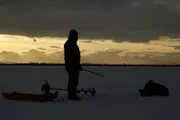 Michael Manzo fishes for pike on a frozen lake in subzero temperatures (National Geographic/Kevin Nowicki).