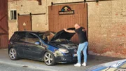 Eine Person überprüft ein Auto.