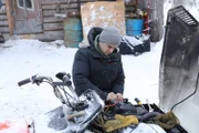 Chris Morse arbeitet daran, sein Schneemobil für die Wintersaison zu reparieren. (Nationial Geographic/Igor Cedeno)