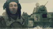 Russian soldier in front of the tank.