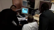 Die Ermittler sehen sich das Filmmaterial an.
