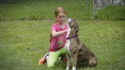 Girl cuddle a dog.