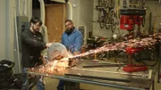 Brannon and Doogie operating a buzz saw in the workshop.