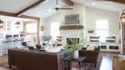 As seen on FIxer Upper, the Eberle's rennovated living room has an open concept floor plan with wood beams and a new stone fireplace. (After #4)