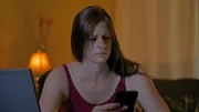 Michele's friend looking concerned at her phone.