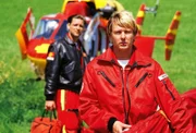 Pilot Thomas Wächter (Manfred Stücklschwaiger, hi.li.) und Sanitäter Peter Berger (Serge Falck) sind am Unfallort angekommen.
